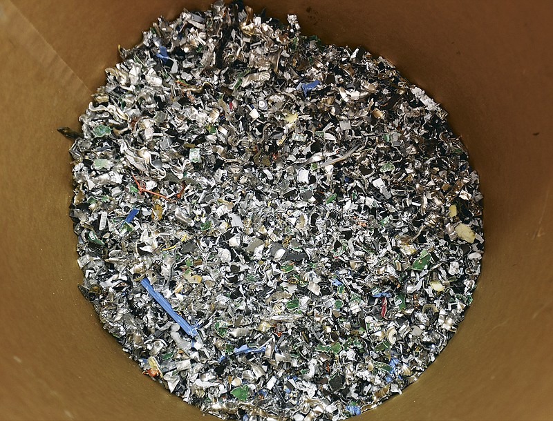Bits of hard drives fill a bin Friday after they're shredded.