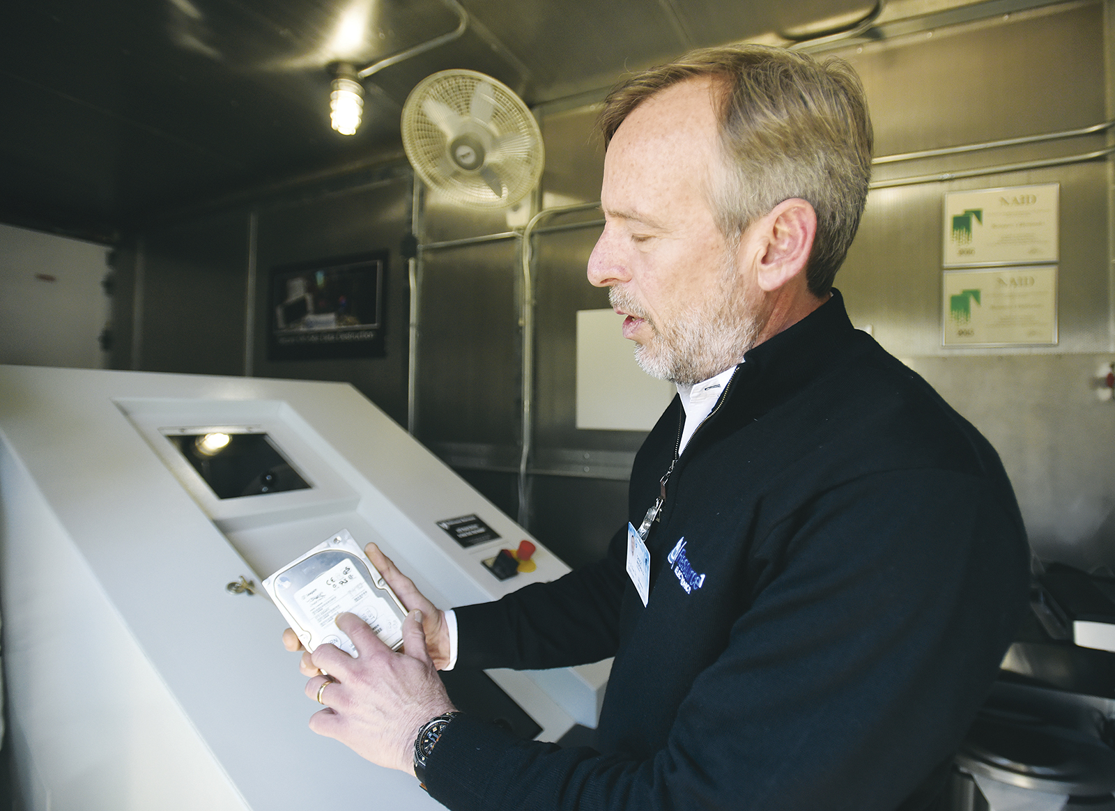 Chuck McDonald, president of Resource 1 Electronics, prepares to shred a hard drive.