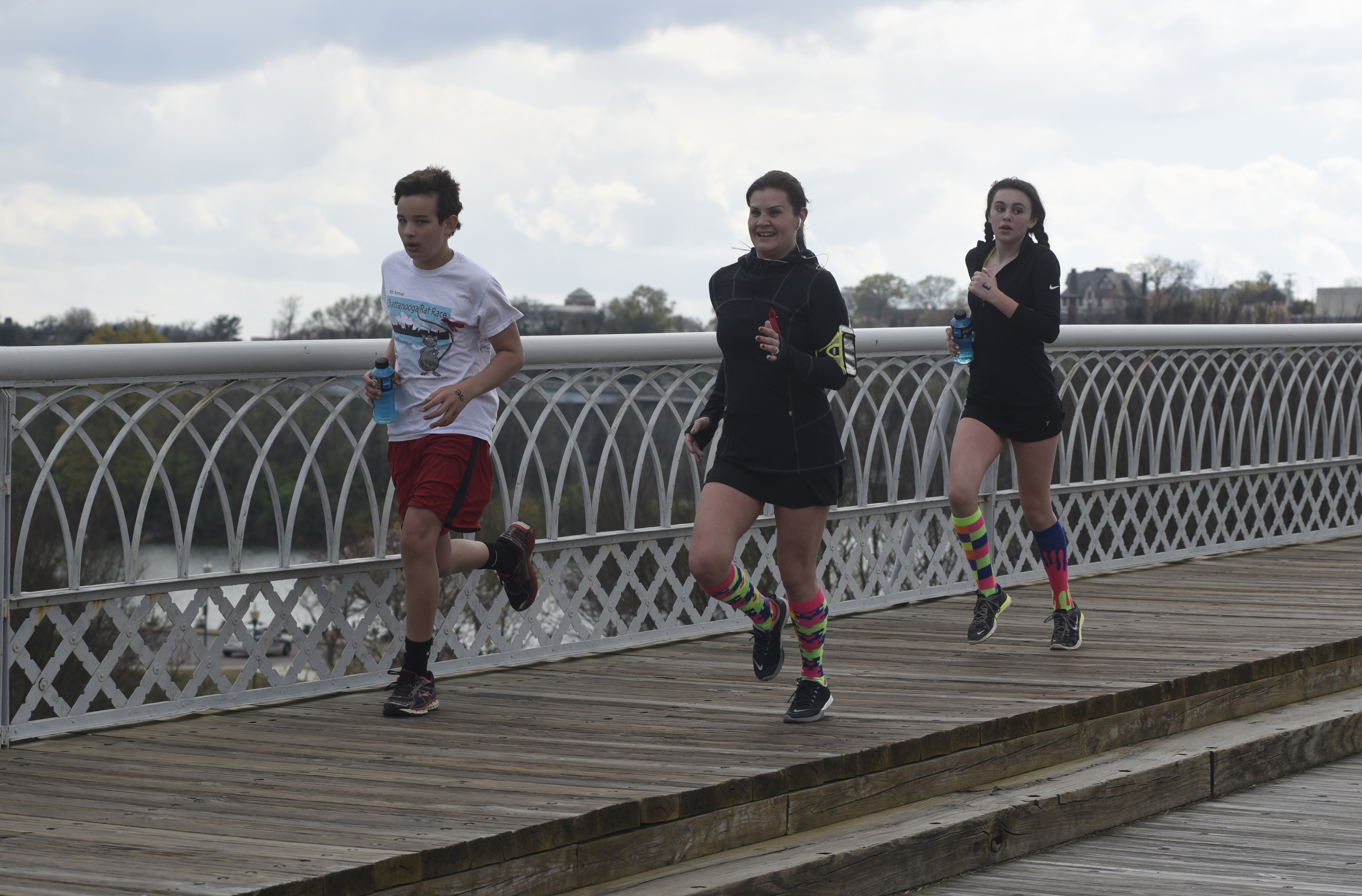Ben Fitzsimmons, Whitney Blankenbaker and Bella Blankenbaker run across the Walnut Street Bridge.