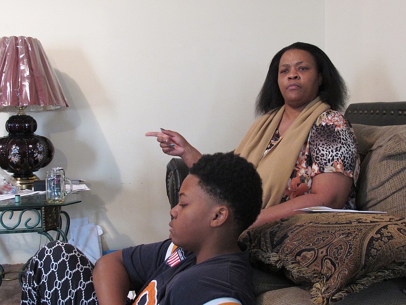 
              Debra Nesbit, right, talks about the shooting of her fiance, Alexio Allen, by a Memphis police officer on Tuesday, March 29, 2016, in Memphis, Tenn. Her 13-year-old son, Larry White, is in the foreground. Nesbit says her fiance, Alexio Allen, was shot in the back on March 23 by an officer as he was surrendering a rifle to her during a confrontation with police, and then again in the chest as he lay dying. contradicting the assertion by investigators that he was killed as the two struggled over the weapon.  (AP Photo/Adrian Sainz)
            