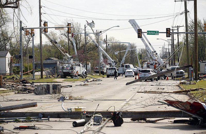 Utility crews work to fix broken power lines and poles at 46th Street North and North Hartford Avenue after a tornado moved through the area the previous night, taken in Tulsa, Okla., Thursday, March 31, 2016. (James Gibbard/Tulsa World via AP)
