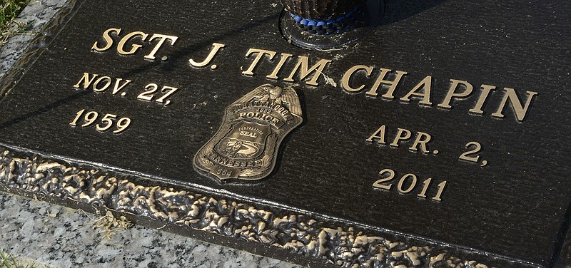 A replica of Chattanooga Police Department Sgt. Tim Chapin's badge is seen on his grave marker at Hamilton Memorial Gardens. Sgt. Chapin was killed in a shootout while responding to a call at the U. S. Money Shops store in Brainerd on April 2, 2011.