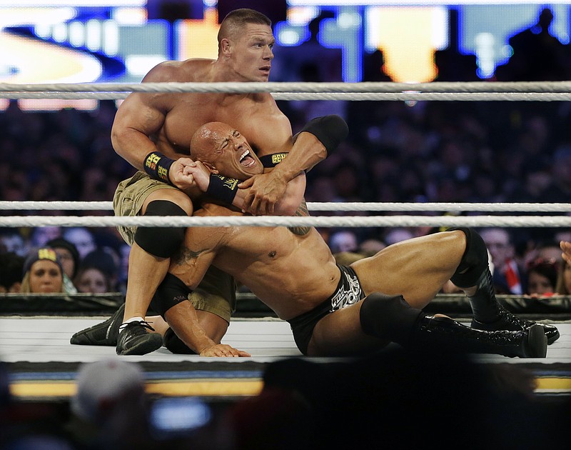 
              FILE -In a Sunday, April 7, 2013 file photo, wrestler John Cena, top, chokes Dwayne Douglas Johnson, known as The Rock as they wrestle during Wrestlemania, in East Rutherford, N.J. WWE bills WrestleMania as its Super Bowl, and is headed to a stadium worthy of a Super Bowl on Sunday, April 3, 2016.  The WWE has lofty expectations of stuffing 100,000 fans inside AT&T Stadium in Arlington, Texas.  (AP Photo/Mel Evans, File)
            