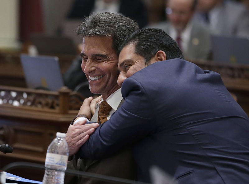 
              State Sen. Mark Leno, D-San Francisco, left, one of the authors of a bill to raise California's minimum wage, is hugged by Sen. Ben Hueso, D-San Diego, as the Senate voted on the bill, Thursday, March 31, 2016, in Sacramento, Calif. The bill, SB3, to gradually raise the state's minimum wage to a nation-leading $15 an hour by 2022, was approved by both houses of the Legislature and sent to Gov. Jerry Brown. (AP Photo/Rich Pedroncelli)
            