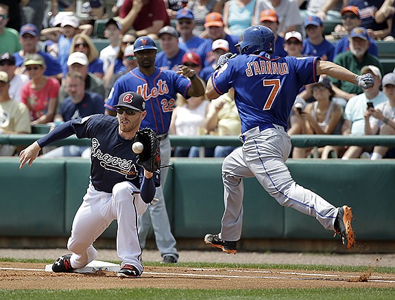 New York Mets' Travis d'Arnaud (7) is unable to beat the throw to Atlanta Braves first baseman Freddie Freeman, left, and is forced out in the first inning of a spring training baseball game, Saturday, March 26, 2016, in Kissimmee, Fla. (AP Photo/John Raoux)