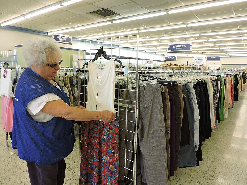 Goodwill sales associate Ann Hunter arranges an outfit on a rack inside the new Fort Oglethorpe store.