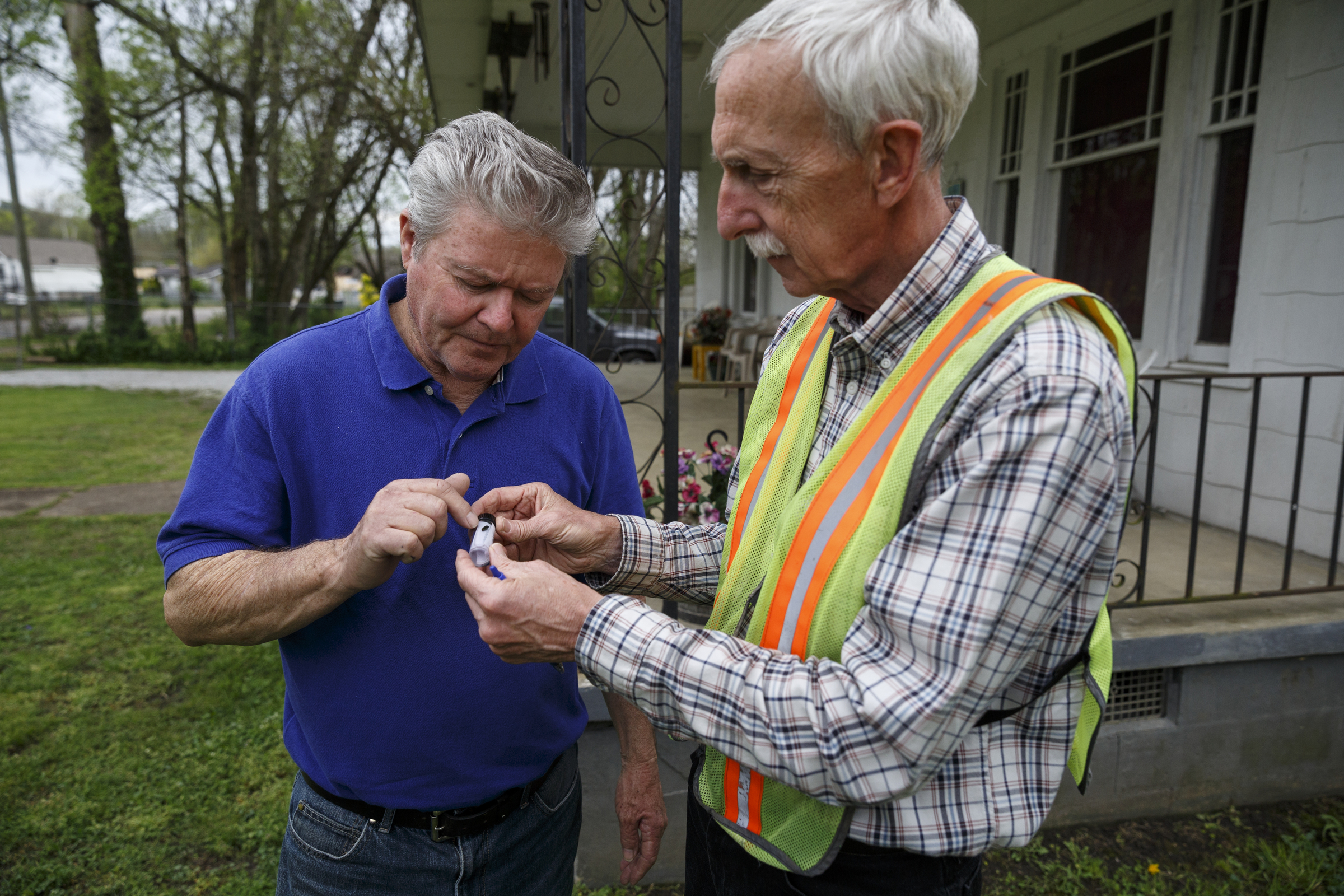 City forester Gene Hyde, right, shows a specimen of an emerald ash beetle to Jimmy Voyles, who has three ash trees infested by the insect, outside his home Friday, April 1, 2016, in Chattanooga, Tenn. The invasive species is threatening the region's estimated 200,000 ash trees.