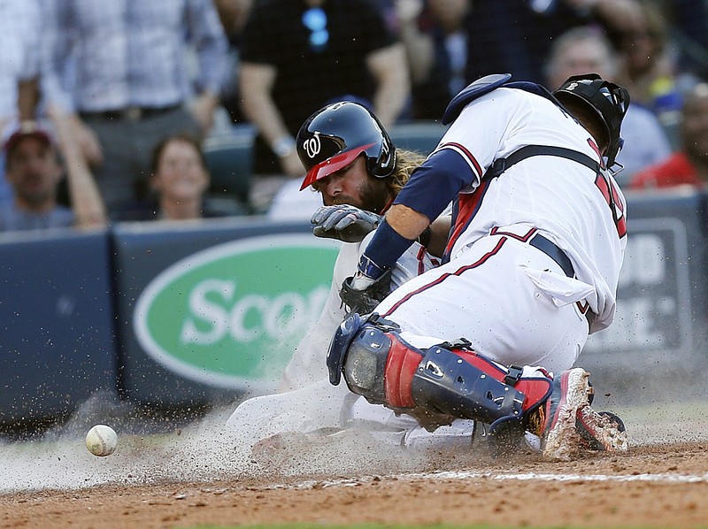 Washington Nationals' Jayson Werth (28) scores the game-tying run on a sacrifice fly by Michael Taylor as the ball gets past Atlanta Braves catcher A.J. Pierzynski (15) inning of a baseball game Monday, April 4, 2016, in Atlanta. (AP Photo/John Bazemore)