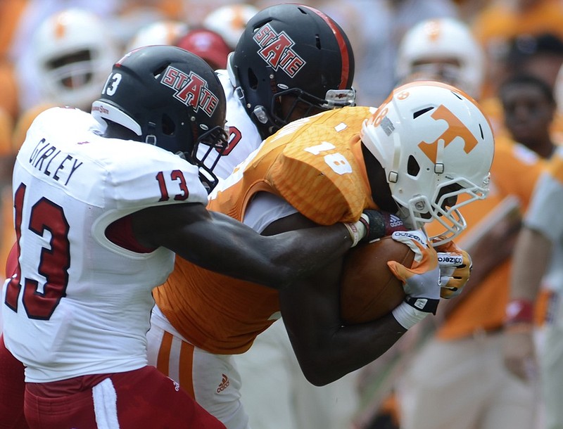 UT's Jason Croom is tackled by Arkansas State's Charleston Girley, left, and Artez Brown Saturday at Neyland Stadium.