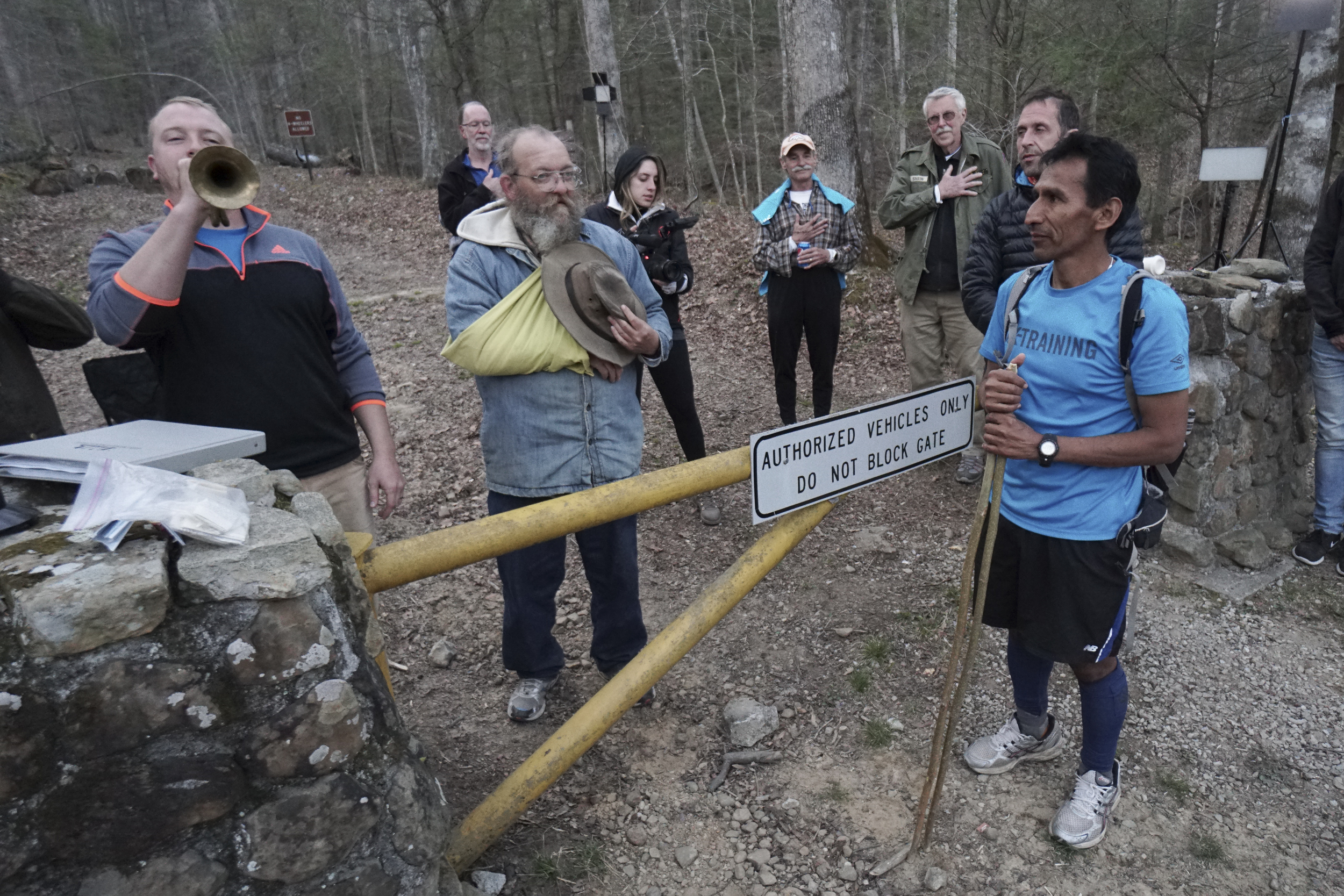 Staff Photo by Dan Henry / The Chattanooga Times Free Press- 4/3/16. "Danger" Dave Henn plays taps on the bugle as Iso Yucra pulls himself from the race during the 30th running of the Barkley Marathons at Frozen Head State Park in Warburg, Tenn., on April 2-4, 2016. The Barkley Marathons is part orienteering, part ultra marathon where a select few attempt to complete up to five 20 mile loops within a 60-hour time limit where they search for hidden book caches deep in the woods throughout the park.