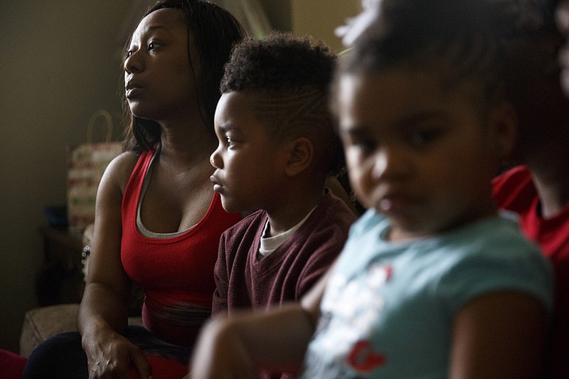 Renee Tellis, left, talks about her brother Edward Glenn Jr., who was robbed and shot to death more than three years ago, while sitting near his son Edward III, center, and niece Jael at her home Thursday, March 31, 2016, in Chattanooga, Tenn. A jury convicted the killer, Stephen Lester, in December 2015.
