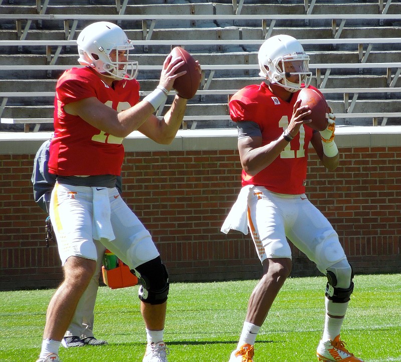 Quarterbacks Quinten Dormady (left) and Josh Dobbs (right) drop back to throw passes in a drill during Tennessee's practice inside Neyland Stadium on April 9, 2016.