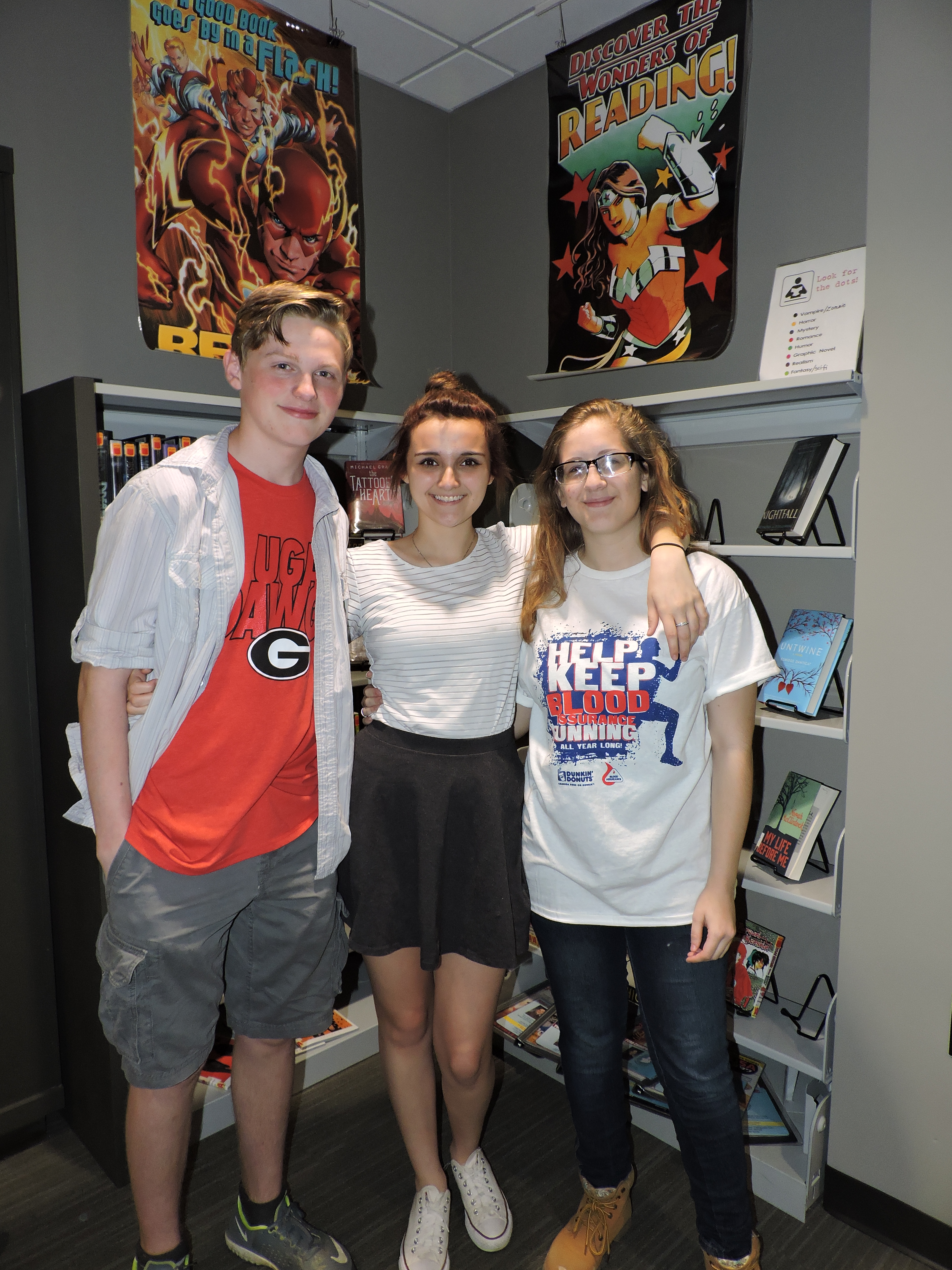 LaFayette High School art students Carson Kirby, Hailee Kerns and Haley Delaney, from left, hang out in the teen section of the LaFayette-Walker County Library. The teenagers helped design the entryway artwork for the library's Children's Department.