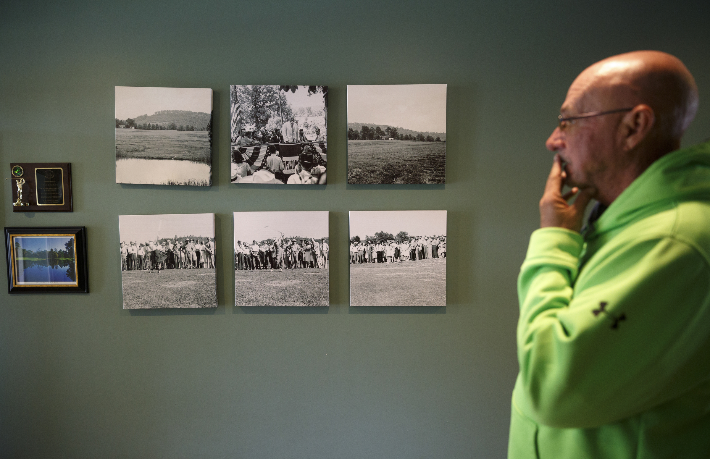 Club pro Eddie Jackson looks at historic photographs on the clubhouse wall at the LaFayette Municipal Golf Course on Friday, April 8, 2016, in Chattanooga, Tenn. The course has been losing about $150,000 a year since 1998.