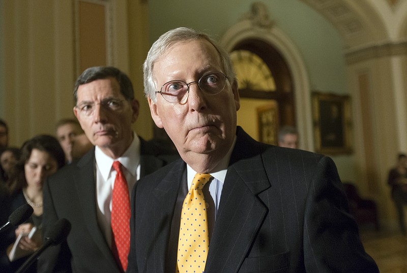 In this March 15, 201,6 file photo, Senate Majority Leader Mitch McConnell of Ky., joined by Sen. John Barrasso, R-Wyo., left, talks to reporters on Capitol Hill in Washington.