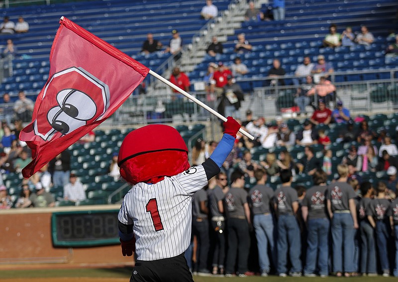 Mascot Louie holds a flag as the Chattanooga Boys Choir sings the National Anthem to start the Lookouts' home opener against the Generals at AT&T Field on Tuesday, April 12, 2016, in Chattanooga, Tenn.