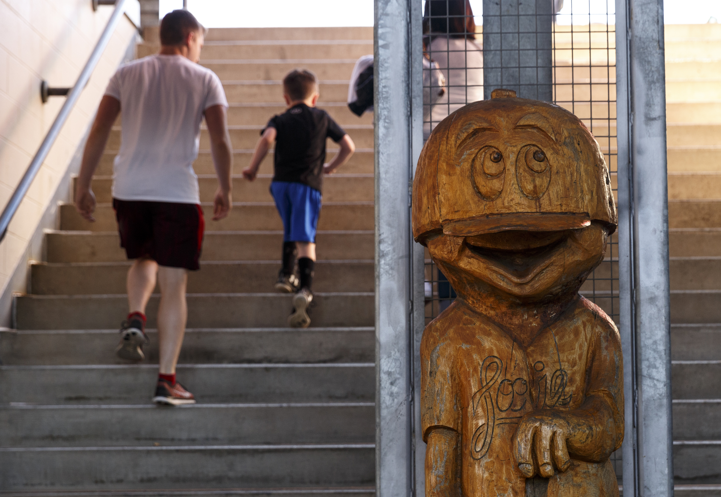 Fans walk up the steps past a wooden sculpture of mascot Louie for the Lookouts' home opener against the Generals at AT&T Field on Tuesday, April 12, 2016, in Chattanooga, Tenn.