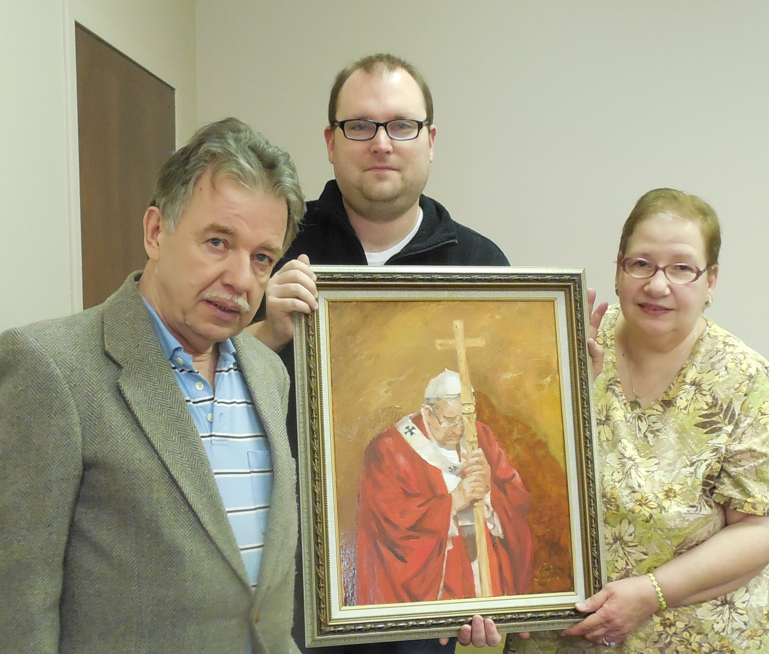 Daniel Swanger, from left, Hans Humberger and Angela Gann hold Swanger's painting,