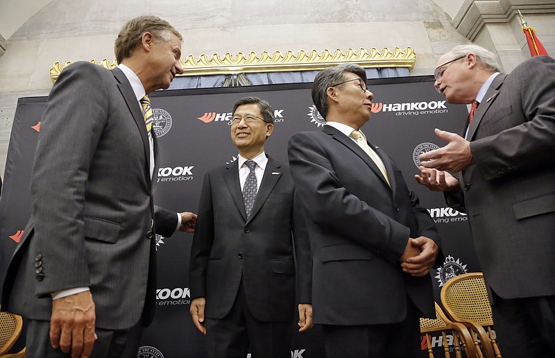 
              Tennessee Gov. Bill Haslam, left, talks with S. H. John Sun, vice chairman and CEO of Hankook Tire Wednesday, April 13, 2016, in Nashville, Tenn., after it was announced that Hankook is relocating its North American headquarters from New Jersey to Tennessee. Ralph Schulz, right, president of the Nashville Chamber of Commerce, talks with Hee Se Ahn, president of Hankook Tire America Corp. (AP Photo/Mark Humphrey)
            