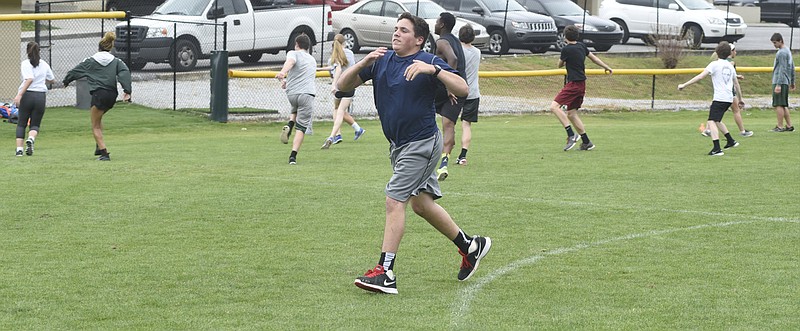Notre Dame freshman David Cowell warms up separately from his teammates at a track and field practice session. He competes in the shot put despite having cerebral palsy.