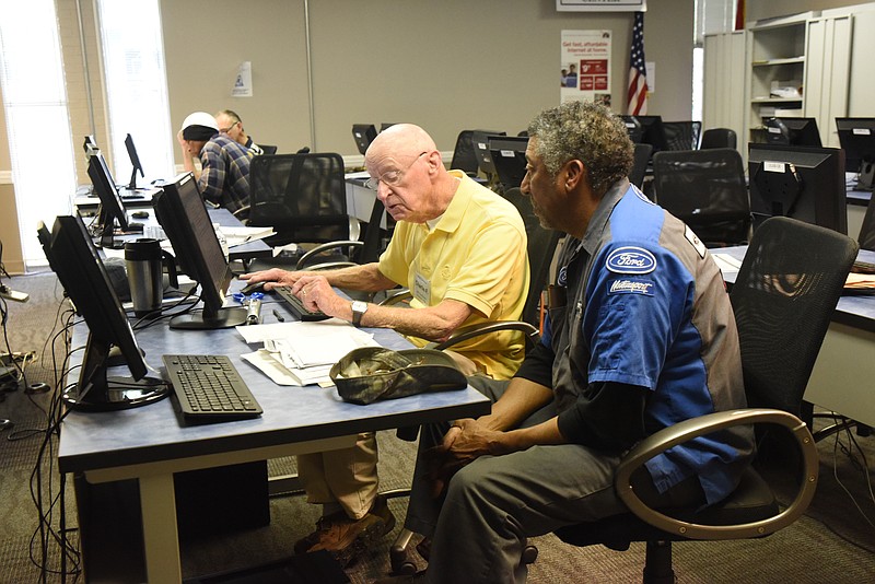 Volunteer Income Tax Assistance preparer Charlie Fox, left, works to help Abraham Jackson with his return on Thursday inside the Urban League at 730 M.L. King Blvd.