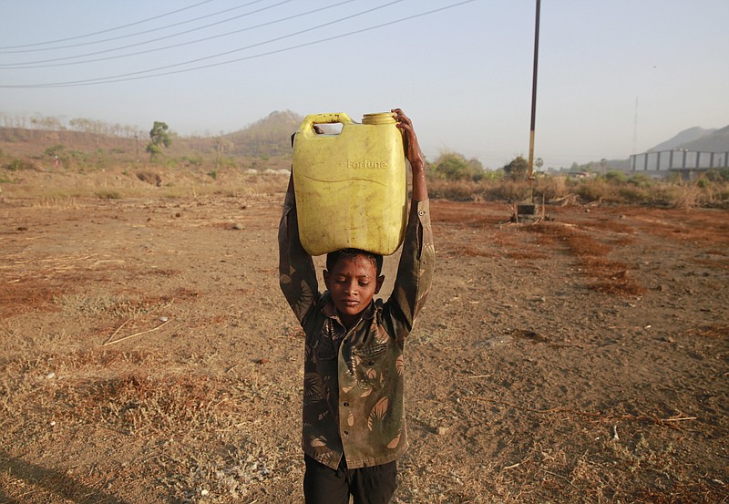 
              In this April 12, 2016 photo, a boy who migrated from drought hit areas of the western Indian state of Maharashtra, carries water to his family's makeshift hut in Kukse Borivali, 85 kilometres (53 miles) north-east of Mumbai, India. Decades of groundwater abuse, populist water policies and poor monsoons have turned vast swaths of central and western India into a dust bowl, driving distressed farmers to suicide or menial day labor in the cities. (AP Photo/Rafiq Maqbool)
            