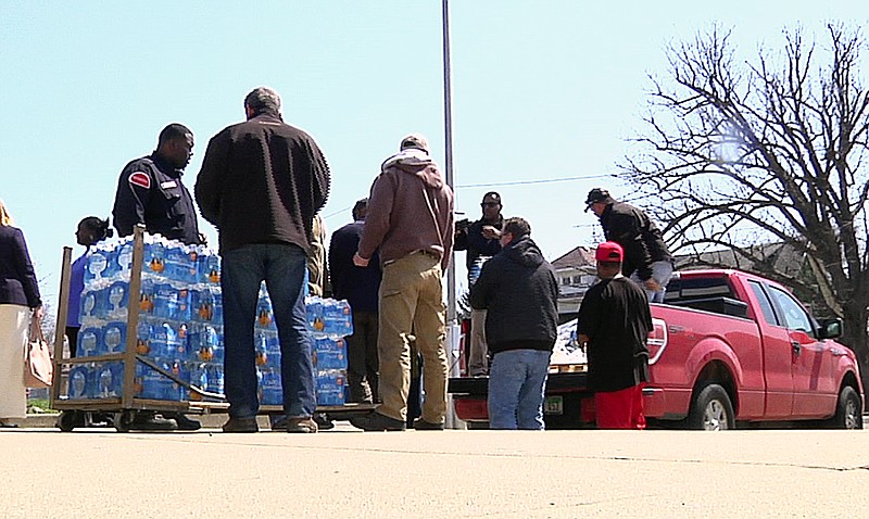 
              In this image made from video, volunteers from the United Auto Workers-Ford and other volunteers unload cases of water outside Sampson-Webber Leadership Academy in Detroit on Thursday, April 14, 2016. The academy is one of 19 schools in Detroit's school district that were found to have elevated levels of lead or copper in their water. (AP Photo/Mike Householder)
            
