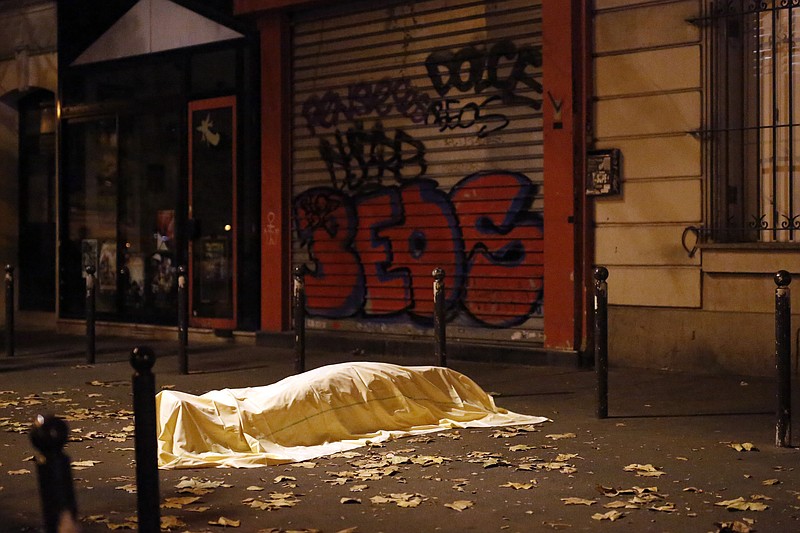 
              FILE -  In this Nov. 13, 2015 file photo, a victim of a terrorist attack lies dead outside the Bataclan theater in Paris. Five people have been arrested in Britain as part of an investigation following the deadly attacks in Paris and Brussels, police said Friday, April 15, 2016. West Midlands Assistant Chief Constable Marcus Beale said the arrests aim to address “any associated threat to the U.K. following the attacks in Europe.’’  (AP Photo/Jerome Delay, File)
            