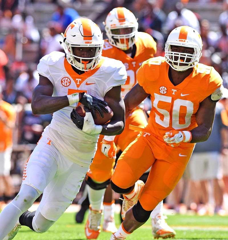 Preston Williams (7) picks up yardage after a pass reception, while Corey Vereen (50) pursues during Tennessee's Orange & White spring football game Saturday at Neyland Stadium in Knoxville.
