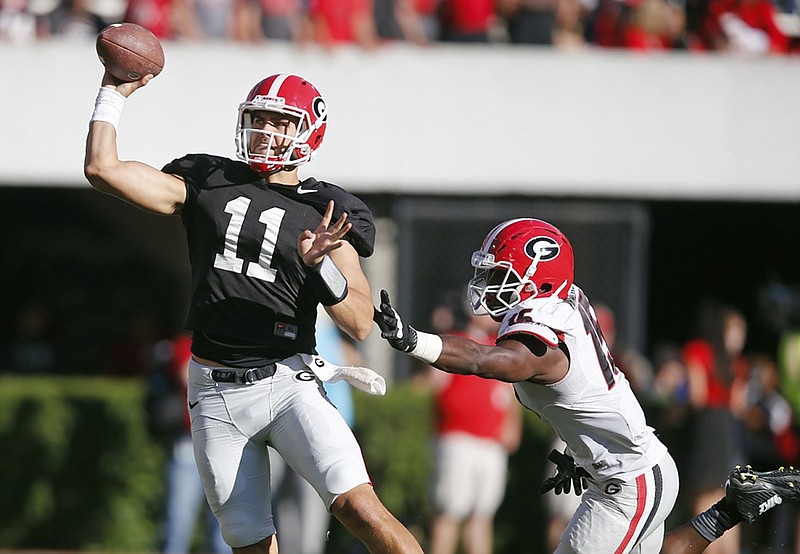 Georgia quarterback Greyson Lambert (11) throws under pressure from linebacker D'Andre Walker (15) during the second half of the NCAA college football team's spring game Saturday, April 16, 2016, in Athens, Ga. (AP Photo/John Bazemore)