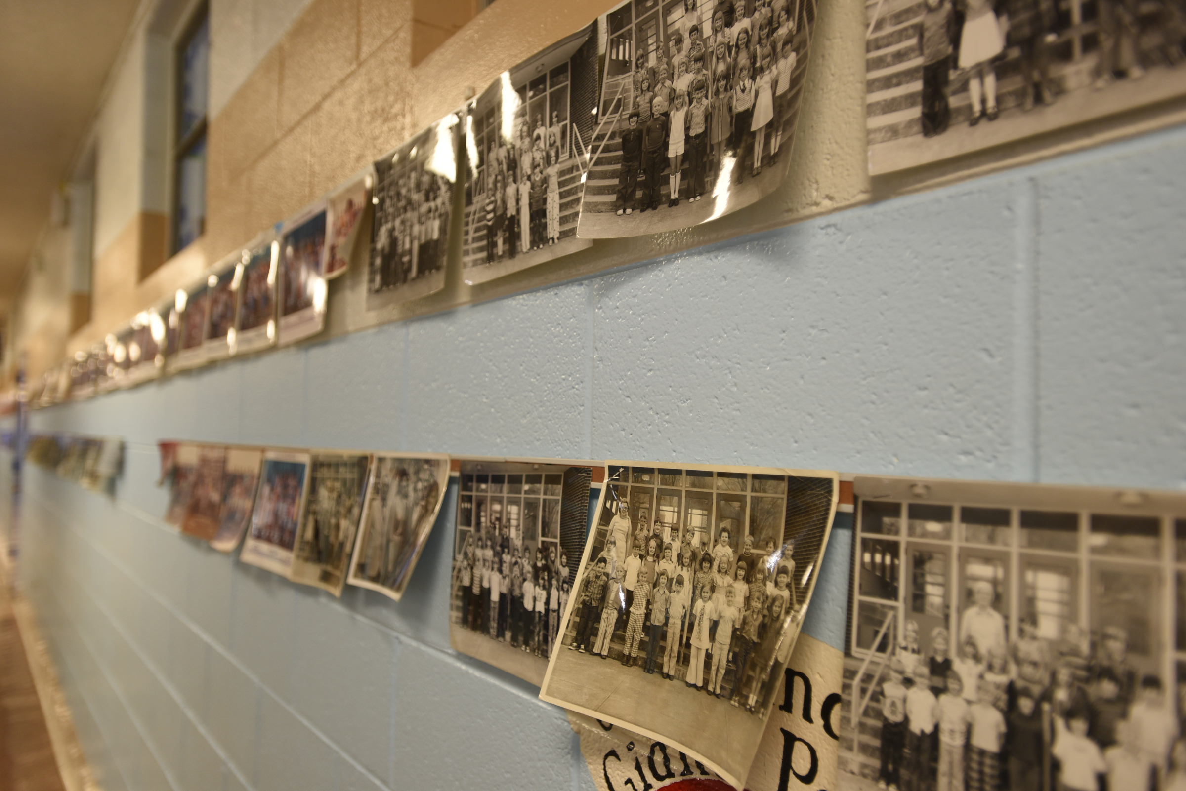 Rows of old class photos line the wall Wednesday, April 13, 2016 at Falling Water Elementary School.