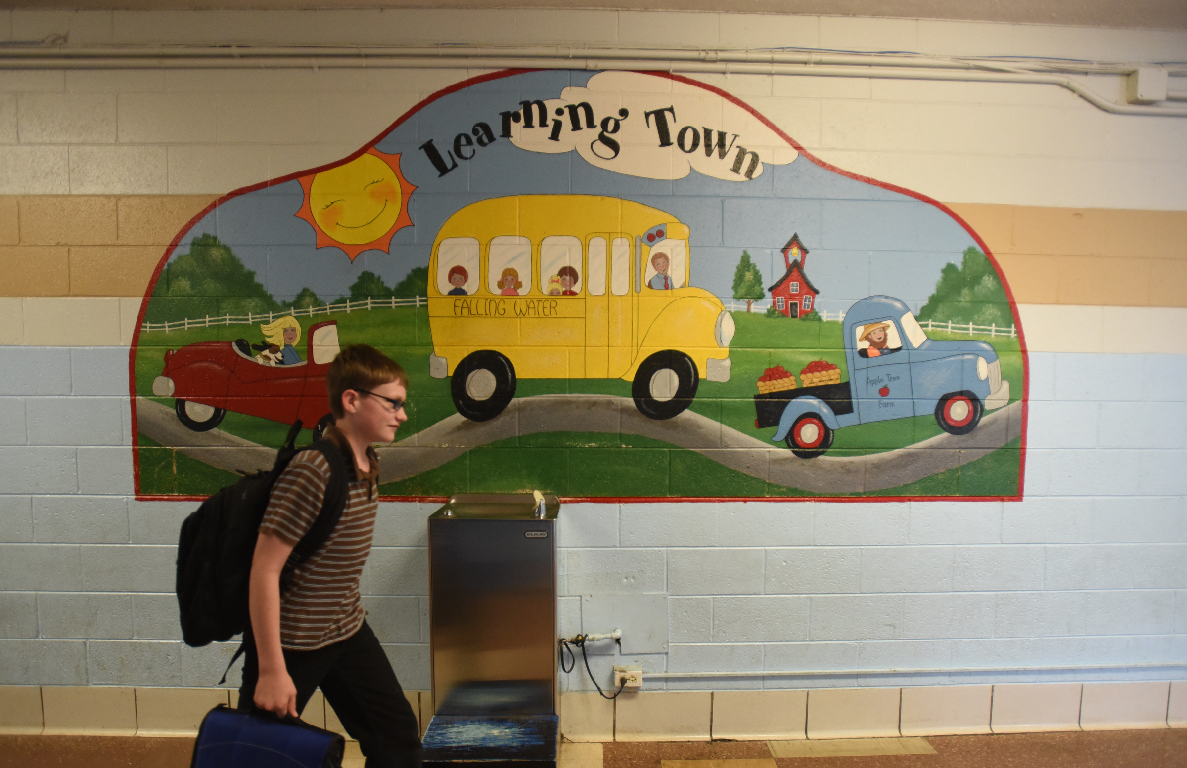 A student walks past a painting Wednesday, April 13, 2016 at Falling Water Elementary School.