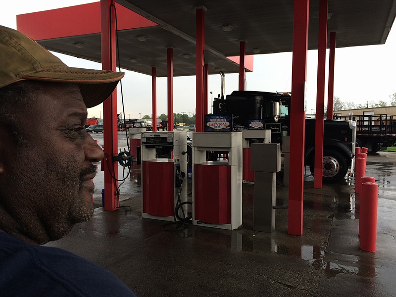 
              In this March 18, 2016 photo, Douglas Randall, a 60-year-old fisherman-turned-oilfield truck driver, stands on a rain-soaked day near his semi-truck parked at a gas station in Houma, LA., awaiting his next job. He is paid per load and works for oil companies, but he says work has dropped off by half due to the low price of oil and a reduction in drilling. Louisiana's oil industry is being clobbered by an unexpected worldwide oversupply of crude oil. The Louisiana Workforce Commission says the state has lost about 12,000 oil and gas jobs since 2014 as gas prices have ebbed. (AP Photo/Cain Burdeau)
            