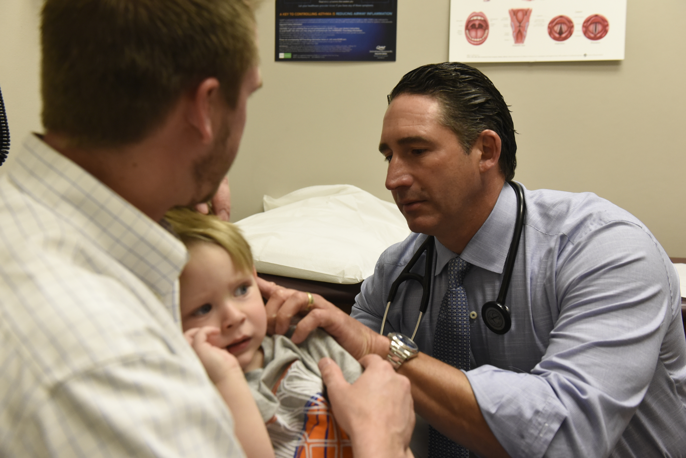 Dr. Mark Cromie examines 2-year-old Brett Fugate, who's being held in the arms of his father, Ryan Fugate, at the Chattanooga Allergy Clinic.