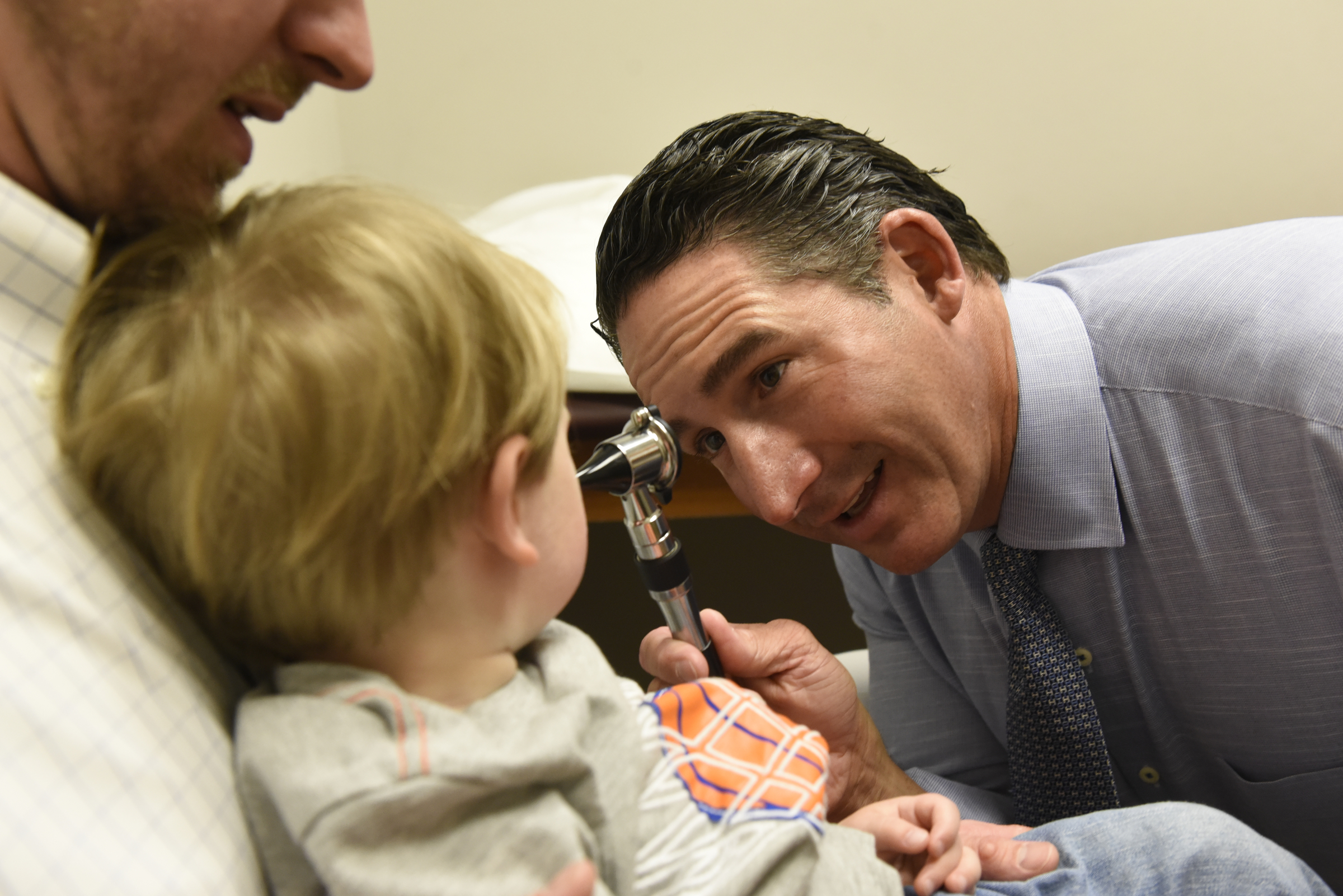 Dr. Mark Cromie examines 2-year-old Brett Fugate, who's being held in the arms of his father, Ryan Fugate, at the Chattanooga Allergy Clinic.