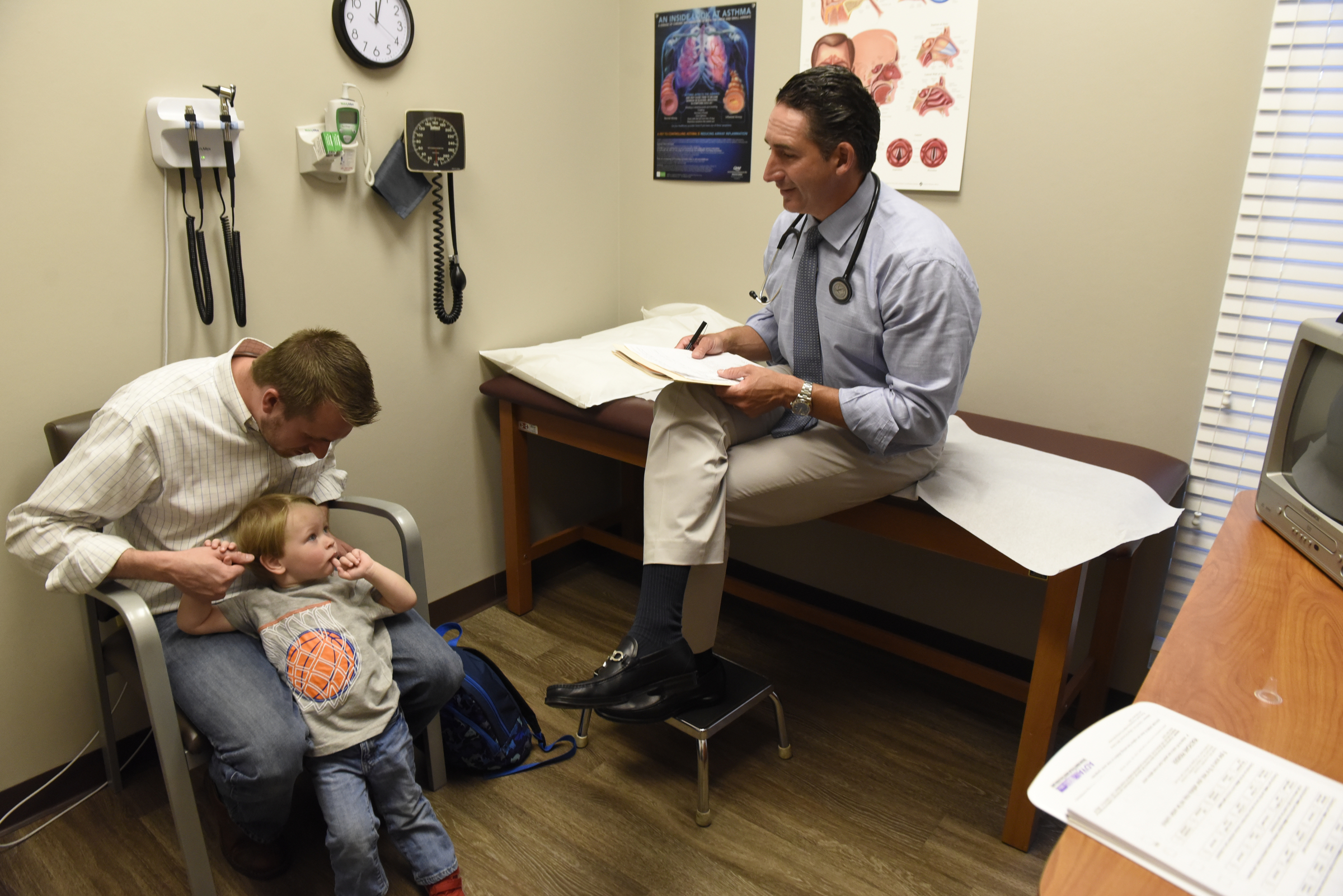Dr. Mark Cromie talks with Ryan Fugate after examining his 2-year-old son, Brett, at the Chattanooga Allergy Clinic.