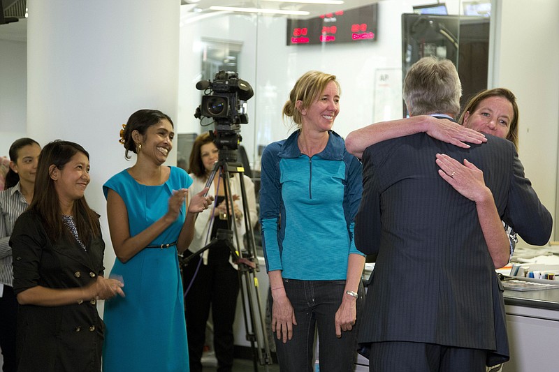 
              Gary Pruitt, back to camera, President and CEO of The Associated Press, embraces reporter Martha Mendoza as the AP wins the Pulitzer Prize for public service, Monday, April 18, 2016 in New York. Mendoza, Robin McDowell, center, Esther Htusan, far left, and Margie Mason, not seen, chronicled how men from Myanmar and other countries were being imprisoned, sometimes in cages, in an island village in Indonesia and forced to work on fishing vessels. AP's international enterprise editor Mary Rajkumar, second left, also congratulated the reporters. (AP Photo/Mark Lennihan)
            