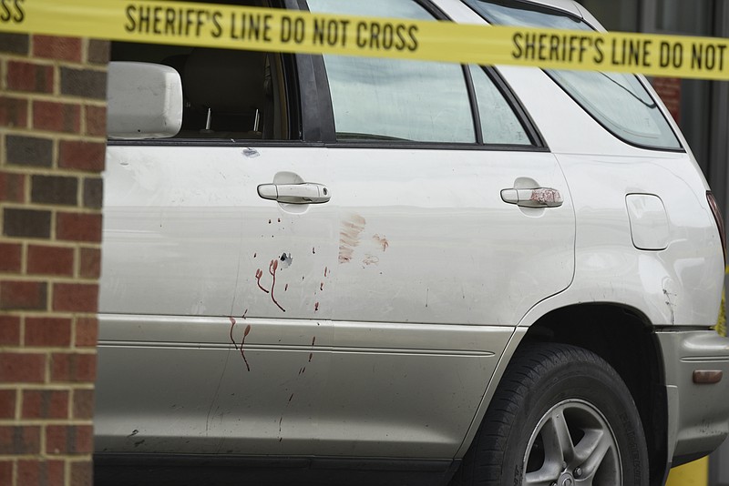 An SUV with a bullet hole in the driver's side door and blood stains down the side is seen behind police tape at the door to the emergency room at Erlanger Medical Center on Tuesday, Apr. 19, 2016, in Chattanooga, Tenn. 