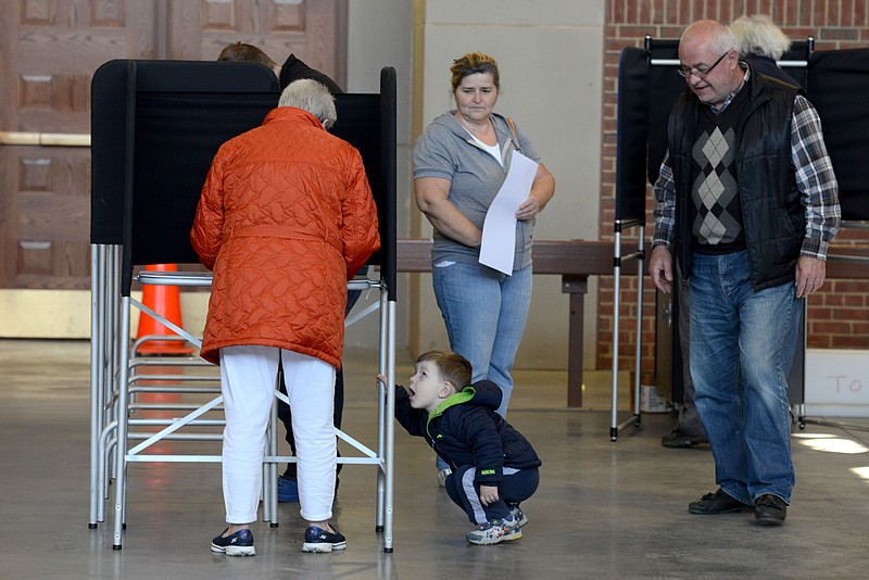 
              Elmir Nuhanovic, center, crouches down on the floor as his grandfather, Ekrem Nuhanovic watches over him during voting for the New York presidential primaries at the Utica Armory Tuesday, April 19, 2016, in Utica, N.Y.  (Tina Russell/Observer-Dispatch via AP)
            
