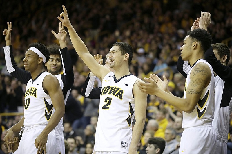 Andrew Fleming, center, celebrates with teammates during an Iowa basketball game last season. Fleming is transferring to UTC and will have three years of eligibility remaining after sitting out the 2016-17 season.