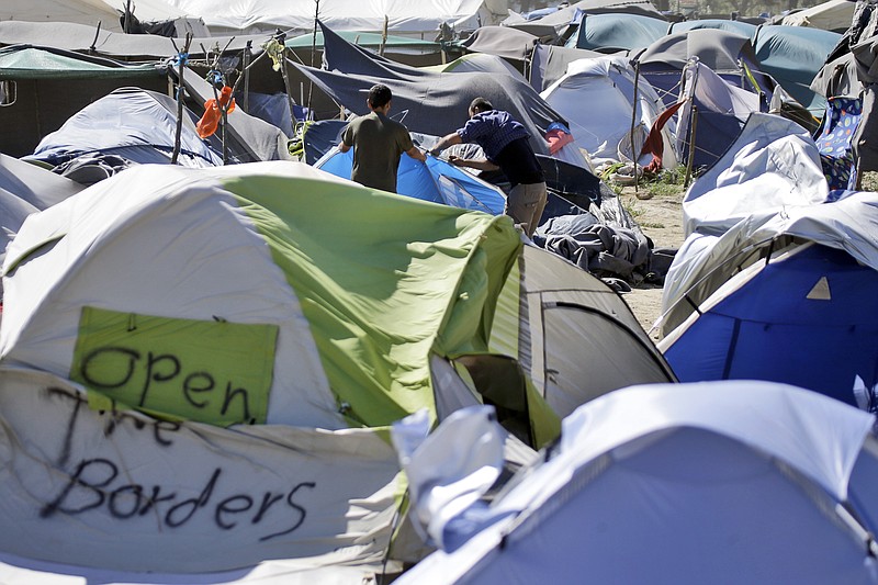 
              Two men set a tent at a camp for migrants and refugees at the northern Greek border point of Idomeni, Greece, Wednesday, April 20, 2016. Human Rights Watch says the initial round of deportations of migrants from Greece to Turkey under a new European Union-Turkey deal were "rushed, chaotic and violated the rights of those deported." (AP Photo/Gregorio Borgia)
            