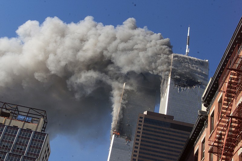 In this Sept. 11, 2001, file photo, smoke rising from the burning twin towers of the World Trade Center after hijacked planes crashed into the towers, in New York City. Every American of a certain age has a 9/11 story -- vivid memories of where they were, what they saw, how they felt on that awful day. Donald Trump is one of them. And for New Yorkers like him, 9/11 melds first-hand experience with what they felt in their guts, what they saw on television and what was playing out in the lives of friends and loved ones in a city under siege. (AP Photo/Richard Drew, File)
            