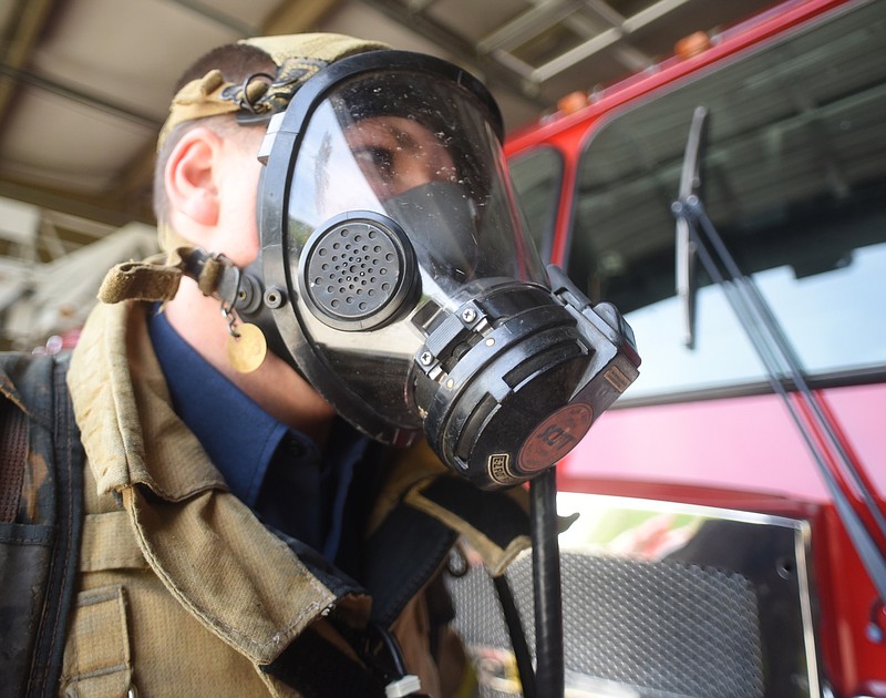 Catoosa County firefighter Nick O'Connell demonstrates the self-contained breathing apparatus that could keep firefighters safe from breathing asbestos.