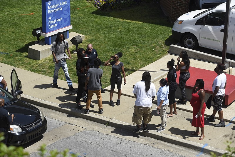 Police officers and citizens gather outside the emergency room at Erlanger hospital on Monday after a shooting vicitm was taken there.