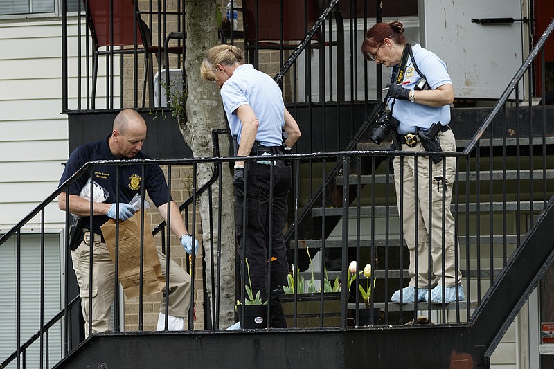Investigators mark evidence outside of an apartment at the scene of a triple-stabbing at Springbrook Apartments on Thursday, April 21, 2016, in Cleveland, Tenn. Two are dead and a third critically wounded in the stabbing, and Cleveland police say a suspect is in custody.