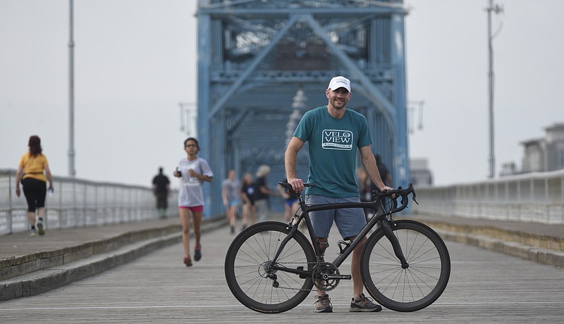 Shannon Burke, owner of Velo View Bike Tours, is photographed on the Walnut Street Bridge on Thursday. Burke is moving his business, his family and his residence from Austin, Texas, to Chattanooga. Velo View Bike Tours specializes in bike vacations across the country.