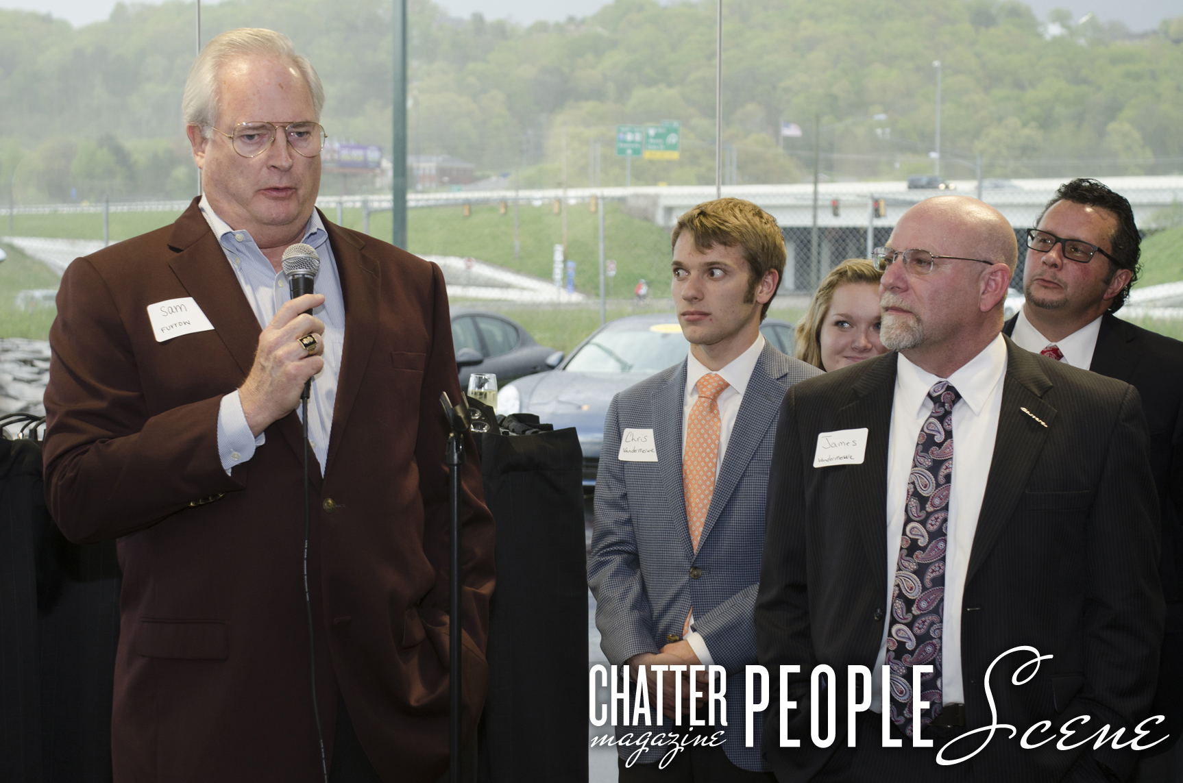 Dealership owner Sam Furrow addresses the crowd while Porsche staff looks on