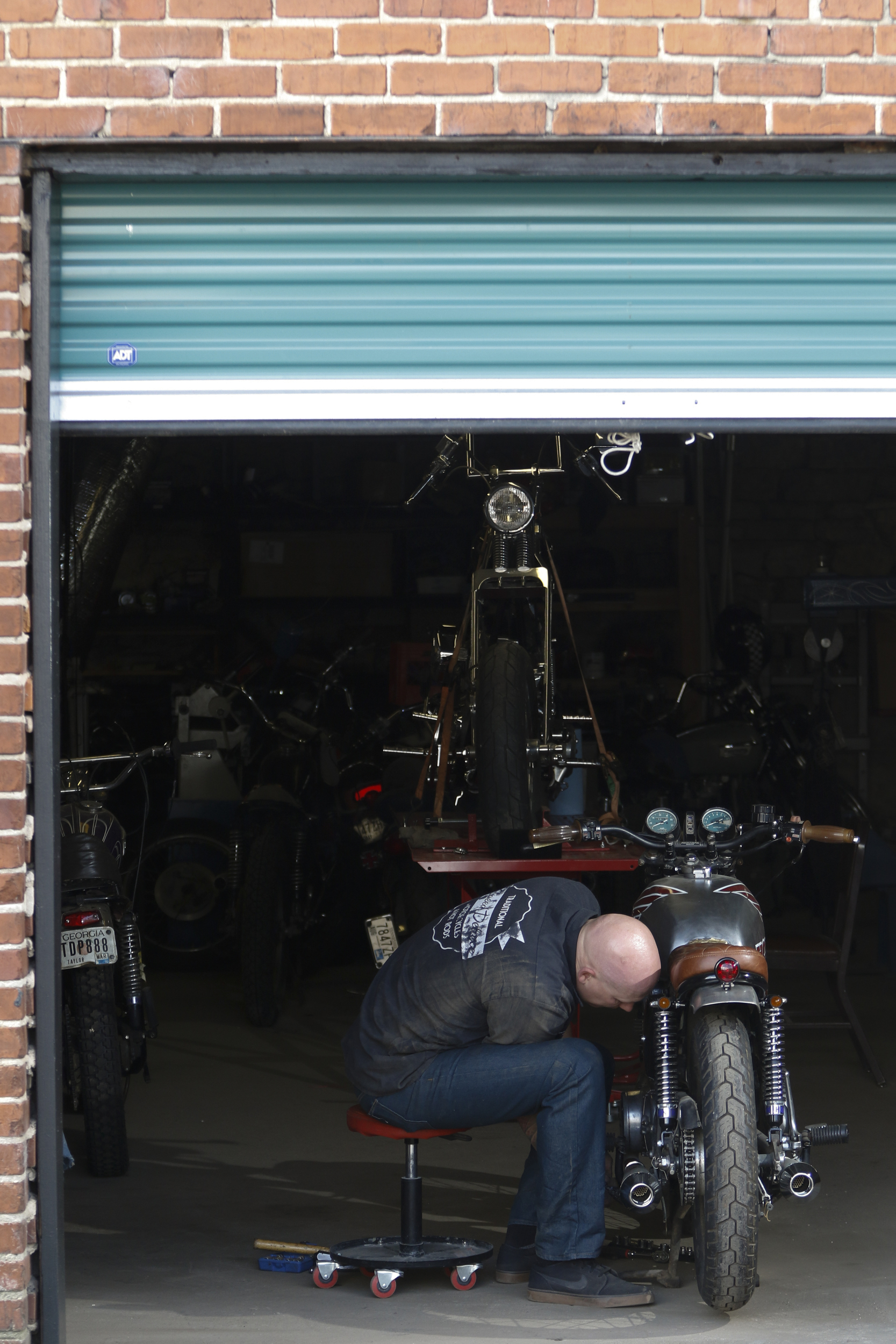 Staff Photo by Dan Henry / The Chattanooga Times Free Press- 3/28/16. Adam Sheard, owner of Speed Deluxe, works on restoring a '72 Honda CB 450 while at his shop's new North Chattanooga location off of Cherokee Boulevard on Monday, March 29, 2016.