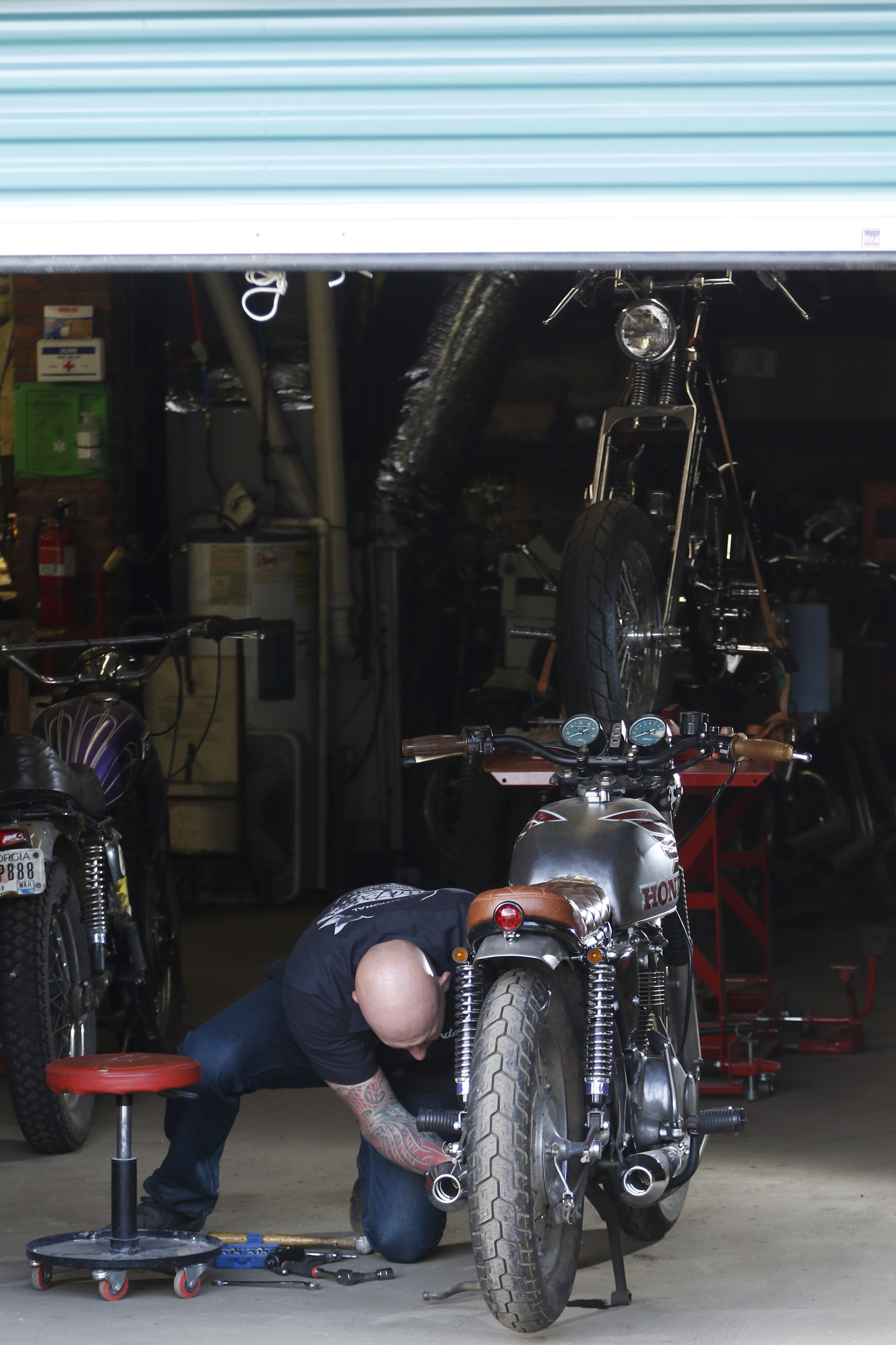 Staff Photo by Dan Henry / The Chattanooga Times Free Press- 3/28/16. Adam Sheard, owner of Speed Deluxe, works on restoring a '72 Honda CB 450 while at his shop's new North Chattanooga location off of Cherokee Boulevard on Monday, March 29, 2016.