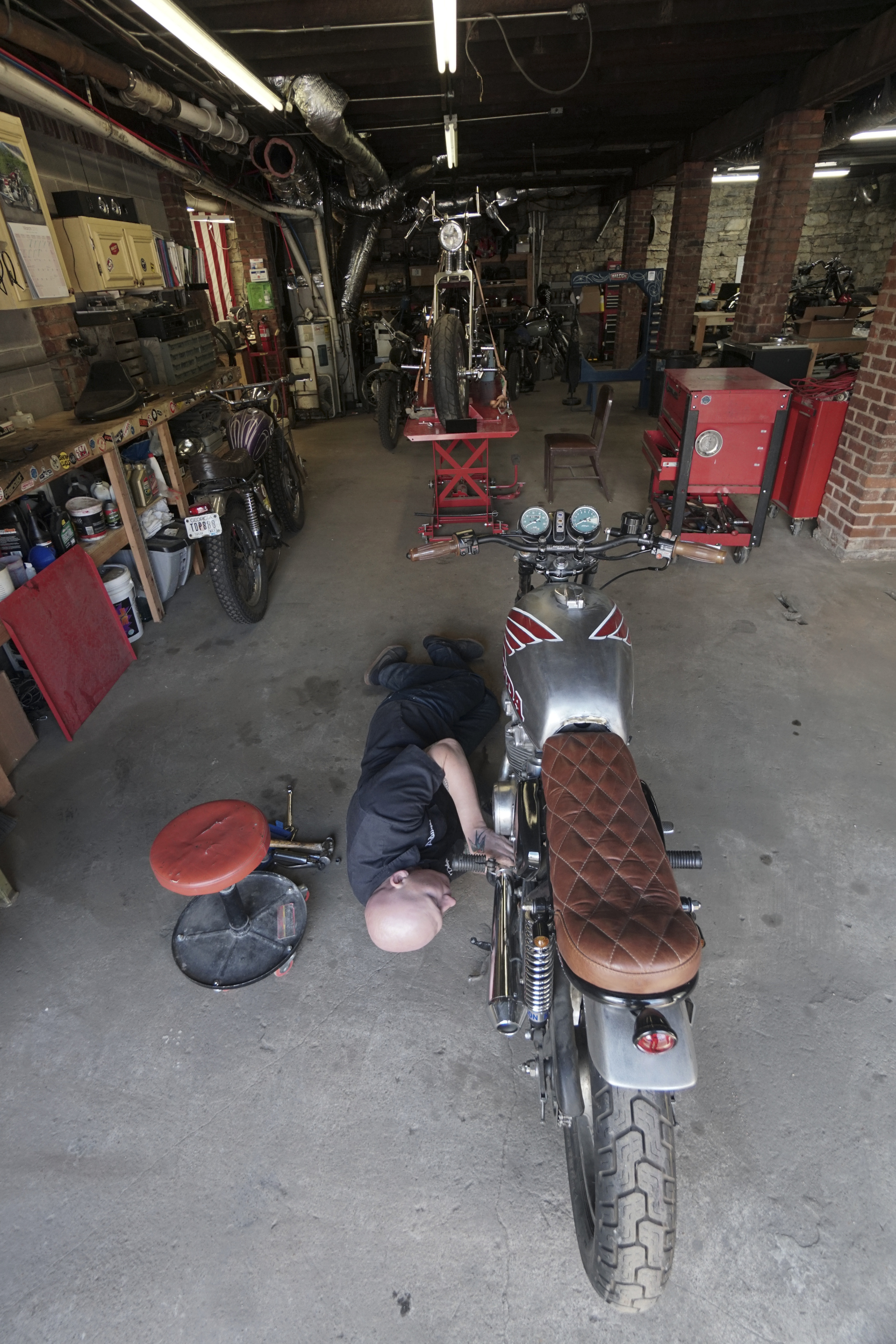 Staff Photo by Dan Henry / The Chattanooga Times Free Press- 3/28/16. Adam Sheard, owner of Speed Deluxe, works on restoring a '72 Honda CB 450 while at his shop's new North Chattanooga location off of Cherokee Boulevard on Monday, March 29, 2016.